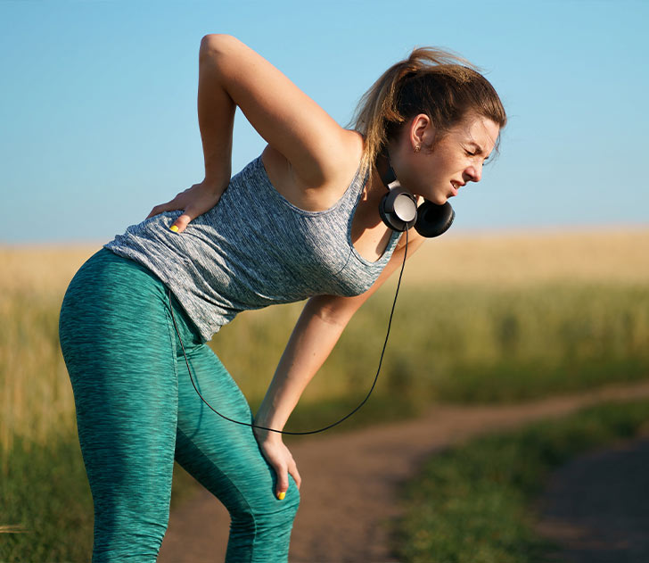 A woman with headphones on and her back turned.