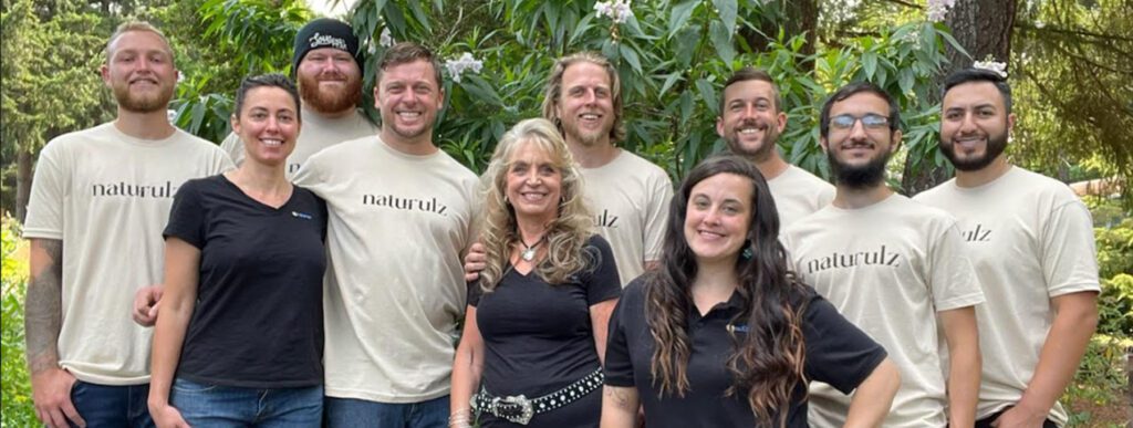 A group of people standing in front of some trees